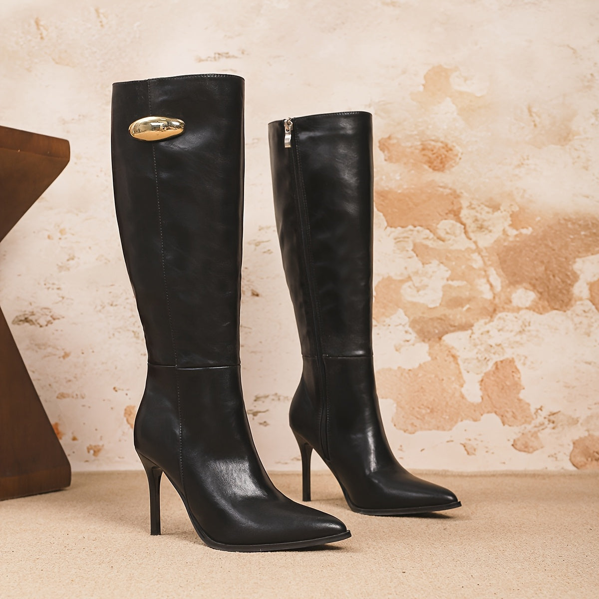 Bottes hautes noires assorties, talon aiguille, bout pointu, boucle dorée au haut.