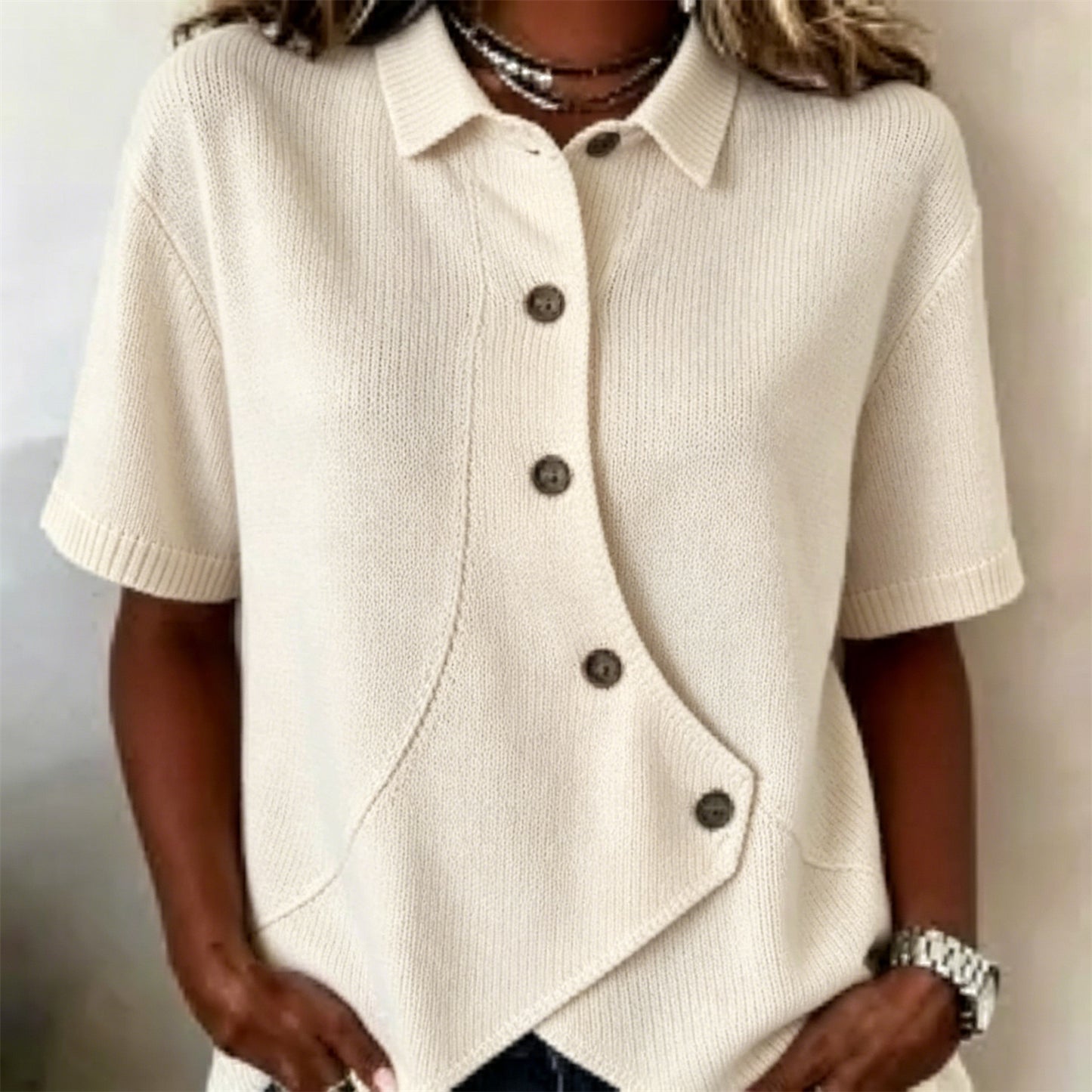 Chemise femme en maille polyester, courte manche, boutonnage asymétrique et col replié.