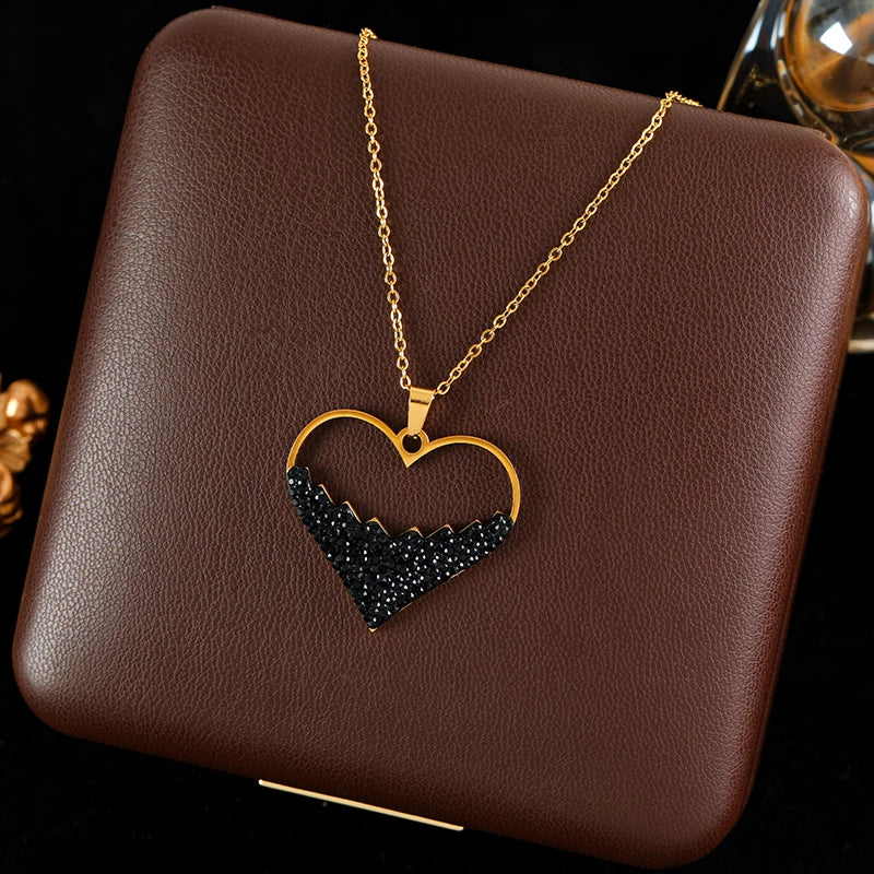 Collier en acier avec pendentif cœur ajouré noir et chaîne dorée