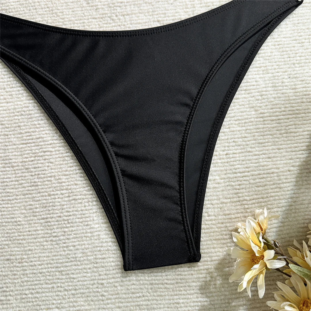 Culotte de bikini noir à taille haute, coutures fines et fond lisse.