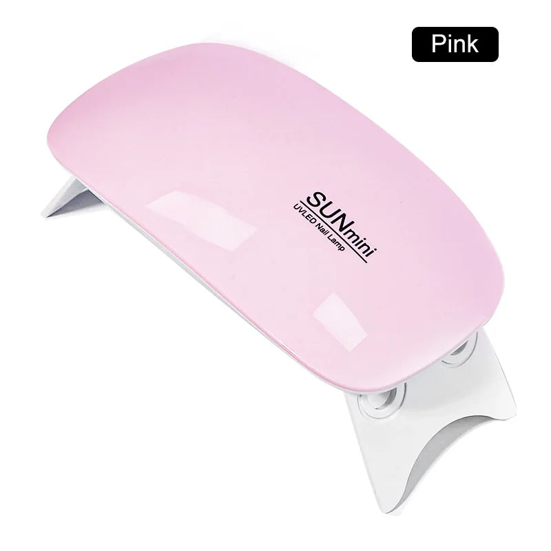 Mini lampe UV LED rose pour ongles, corps rose et base blanche.