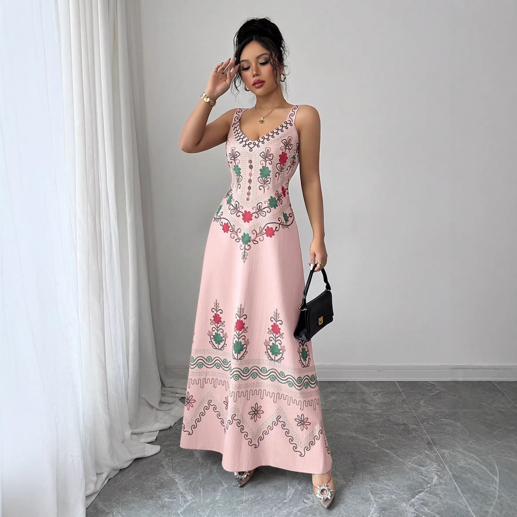 Robe longue fendue à fines bretelles et encolure V, fond rose clair à motifs floraux
