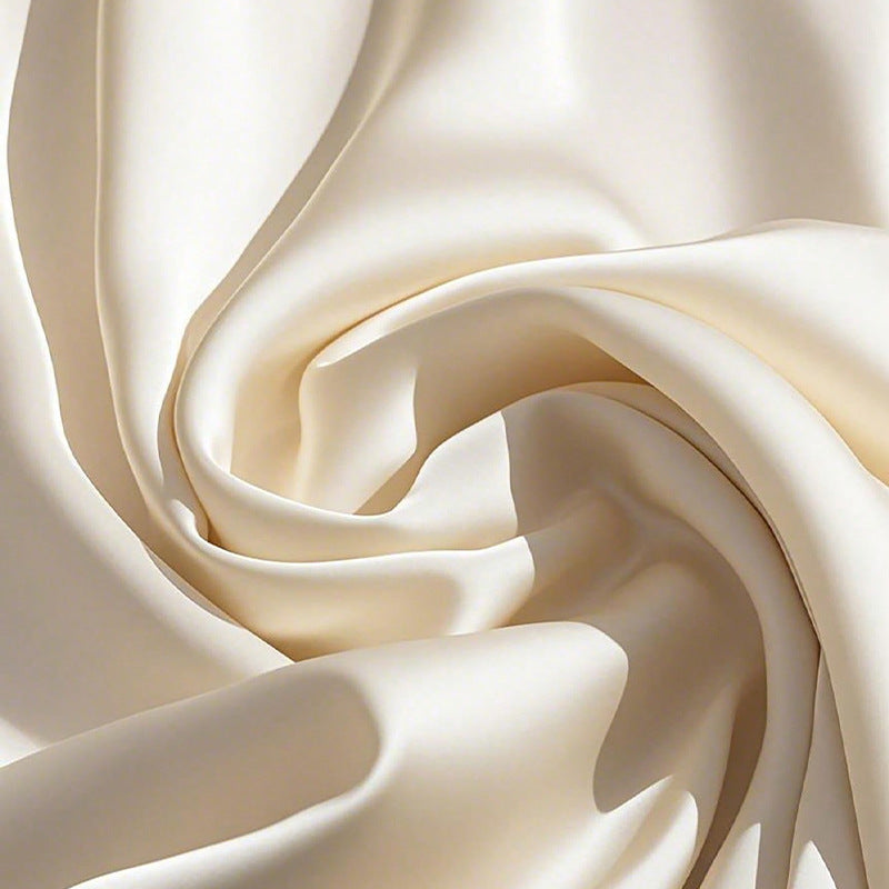 Tissu satin ivoire avec ondulations, surface lisse et brillante pour combinaison