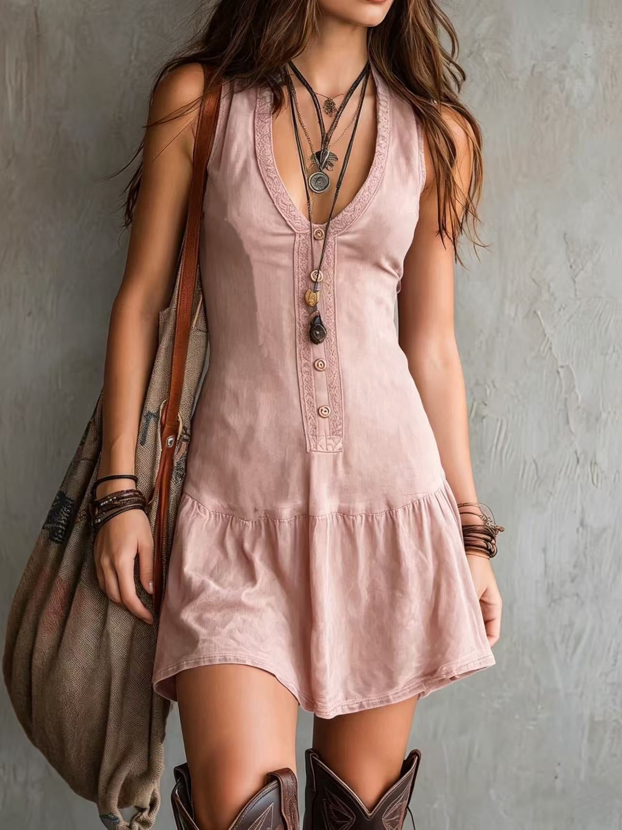 Robe courte sans manches rose pâle à col en U, boutonnage devant et volants.