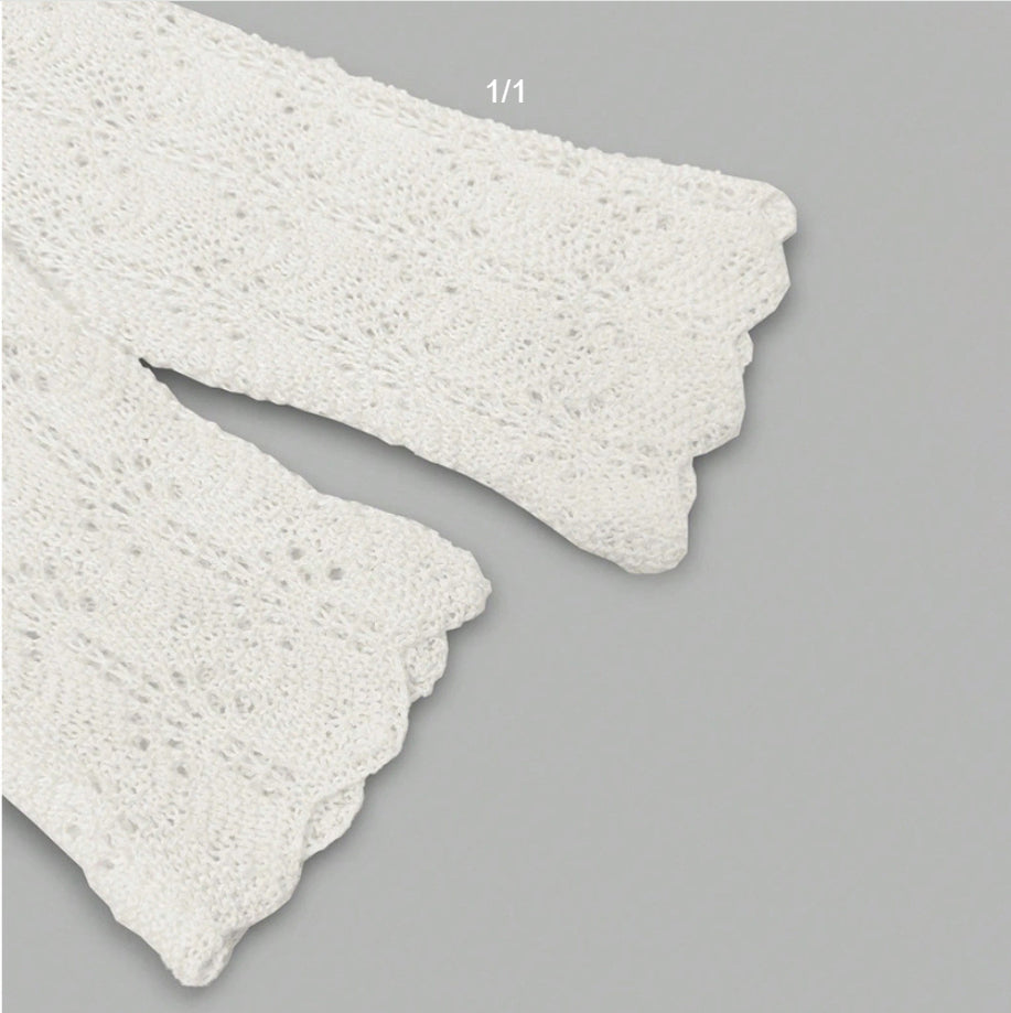 Bas du top femme blanc ajouré, ourlet festonné et coupe évasée