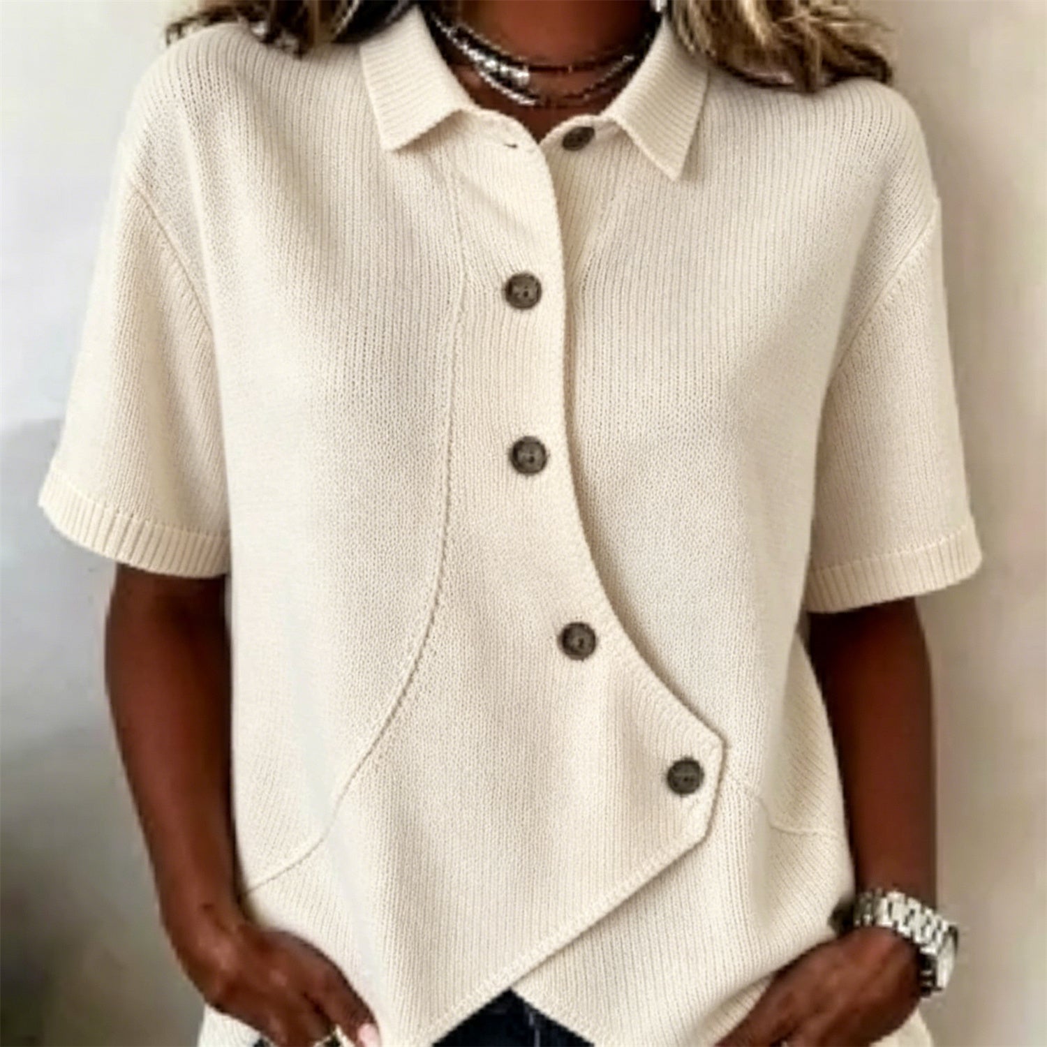 Chemise femme en maille polyester, courte manche, boutonnage asymétrique et col replié.
