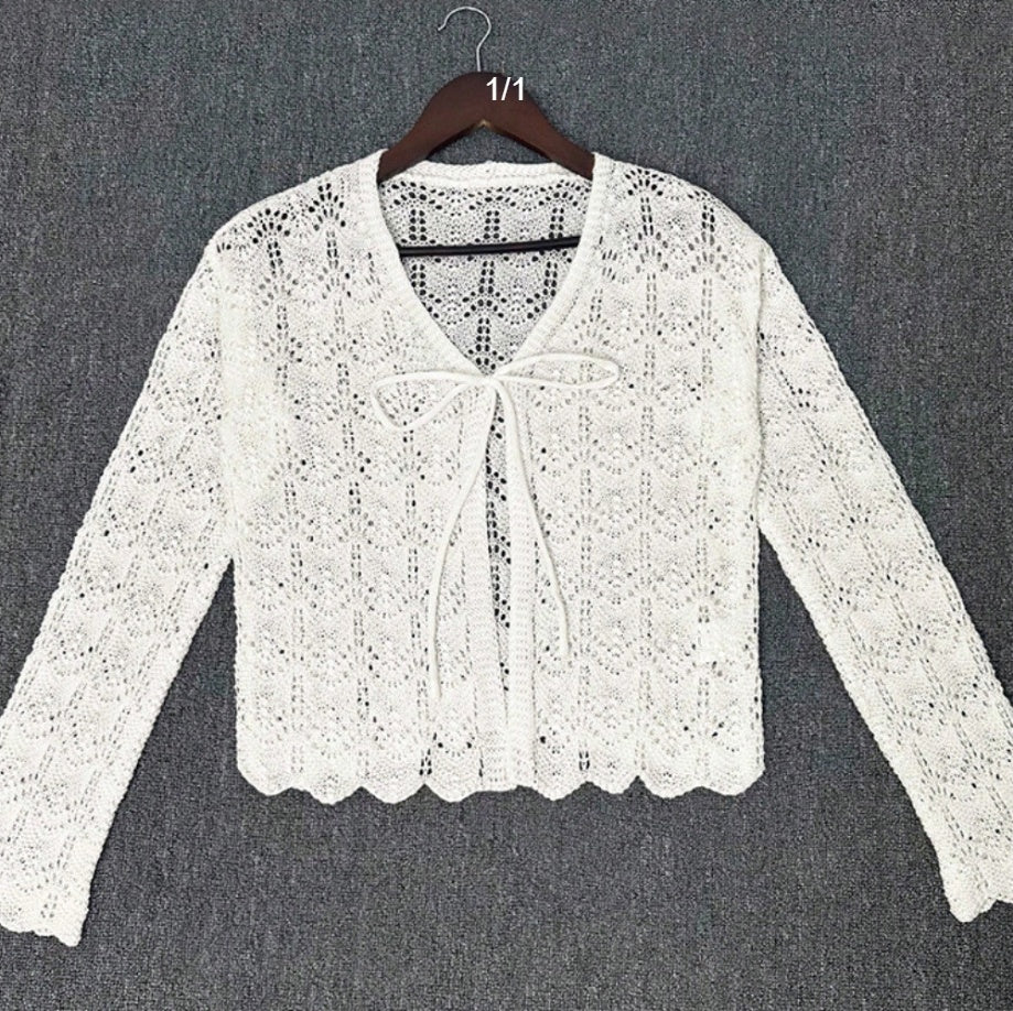 Top femme blanc ajouré col V noué, manches longues, vue de face sur cintre