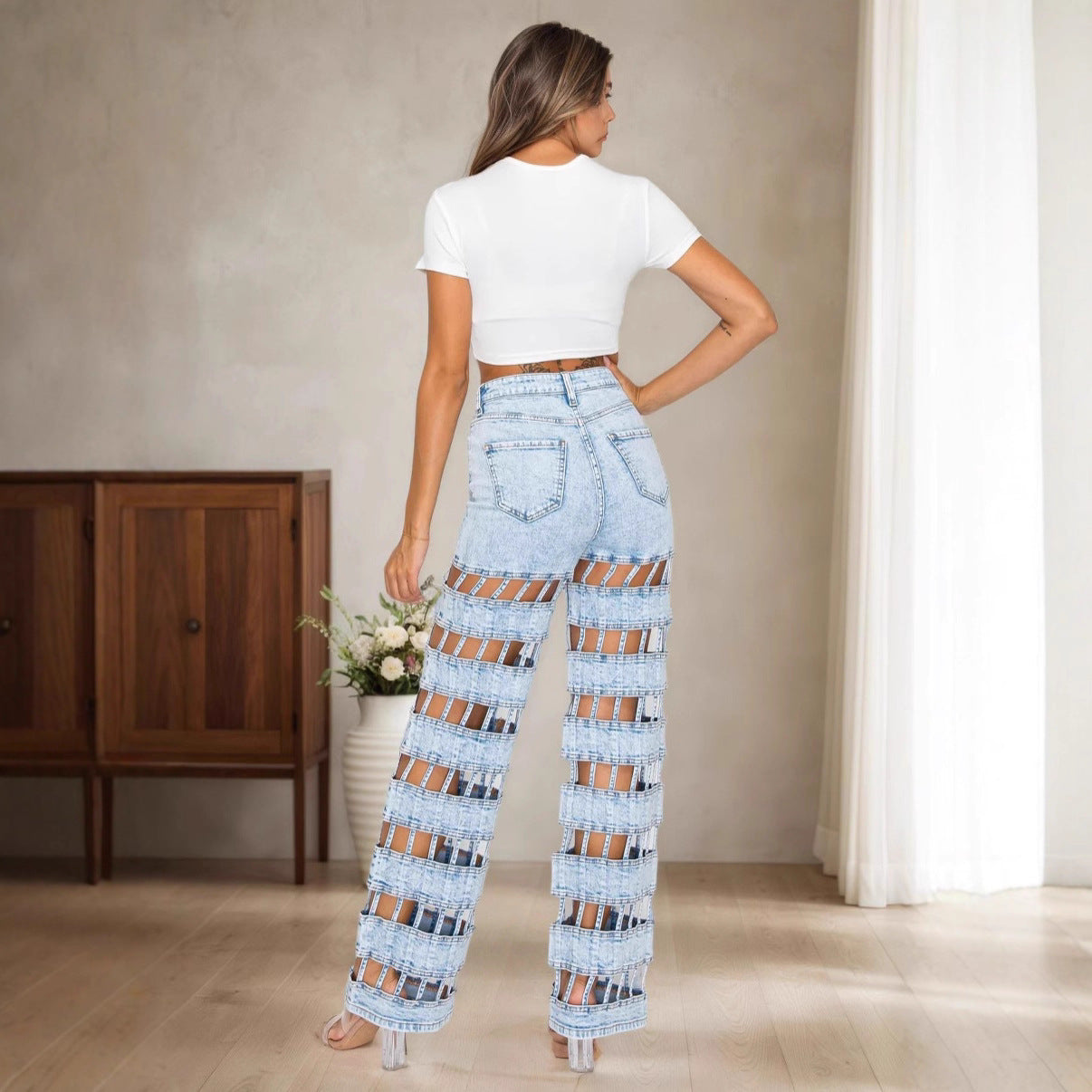 Jean taille haute bleu clair, coupe droite, panneaux à découpes et coutures délavées.