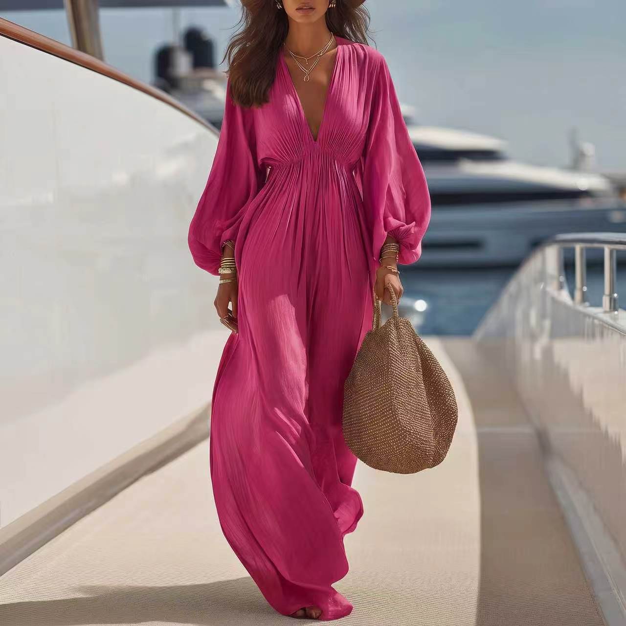 Combinaison ample col V manches longues, tissu rose vif plissé, jambes larges.
