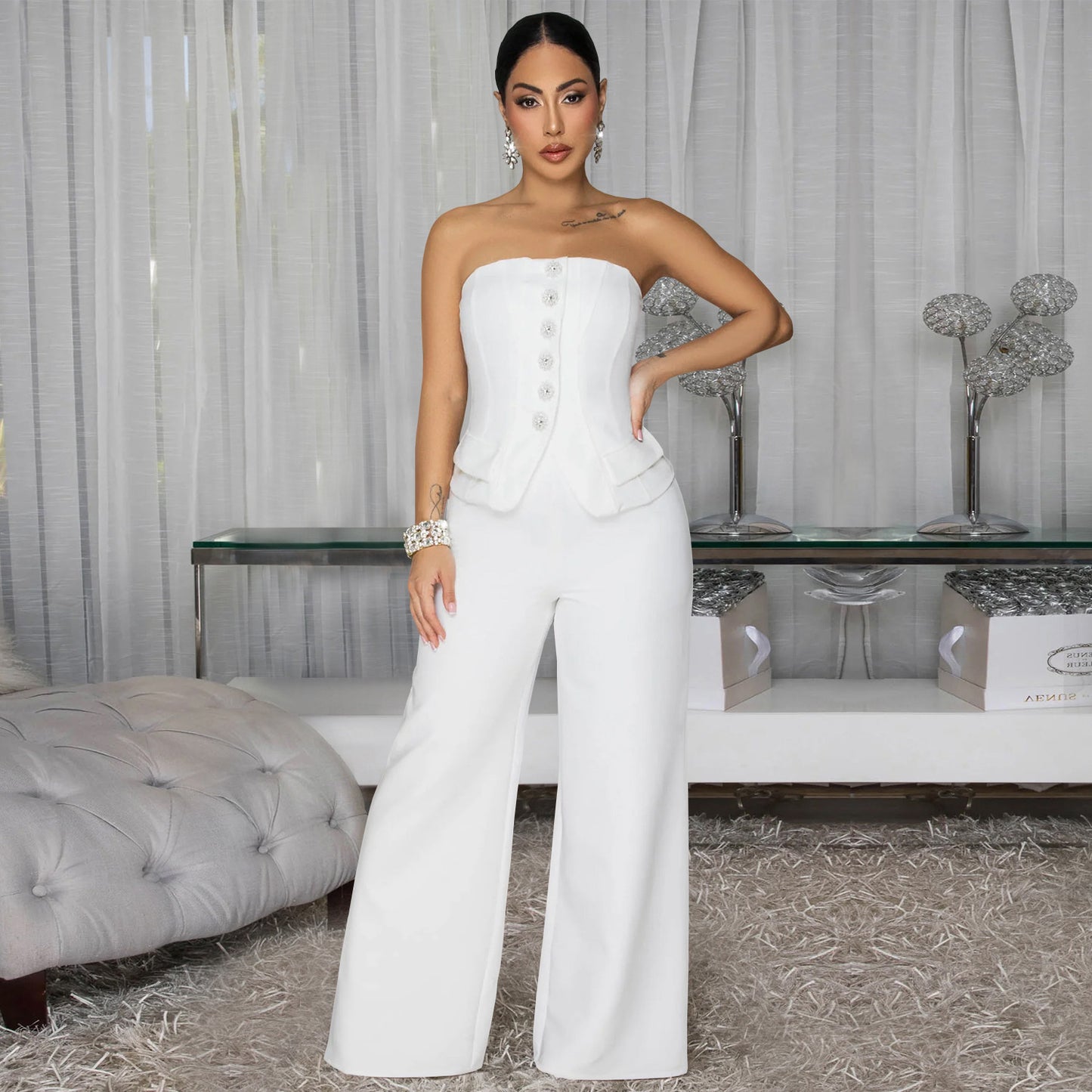 Combinaison bustier dos nu blanche à jambes larges, boutons décoratifs sur le buste.