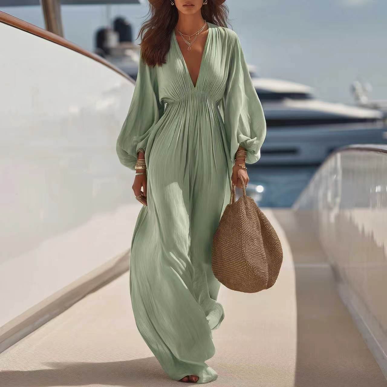 Combinaison ample col V manches longues, tissu vert clair plissé, jambes larges.