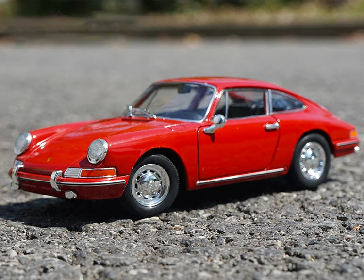 Modèle réduit WELLY Porsche 911 rouge 1:24, vue trois-quarts latérale sur gravier