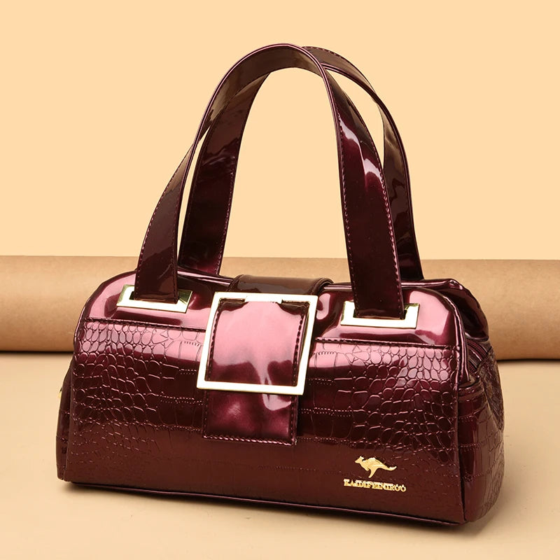 Sac à main en cuir verni effet croco bordeaux, poignées et fermoir rectangulaire doré