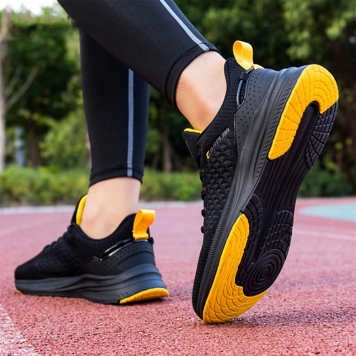 Chaussures de running homme noires, semelle épaisse avec semelle extérieure jaune.