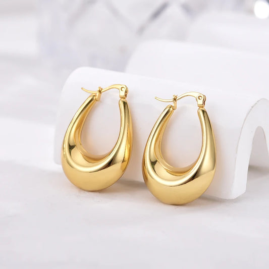 Boucles d’oreilles créoles épaisses dorées en forme ovale, fermoir à charnière.