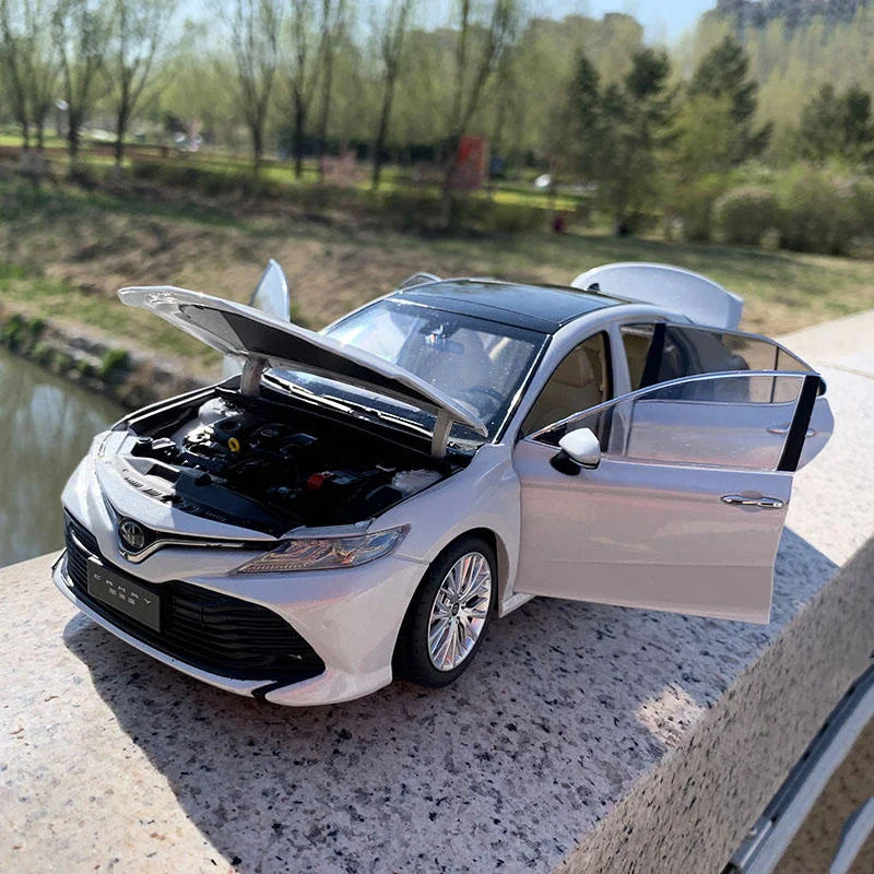 Voiture miniature blanche Toyota Camry, capot relevé et porte ouverte
