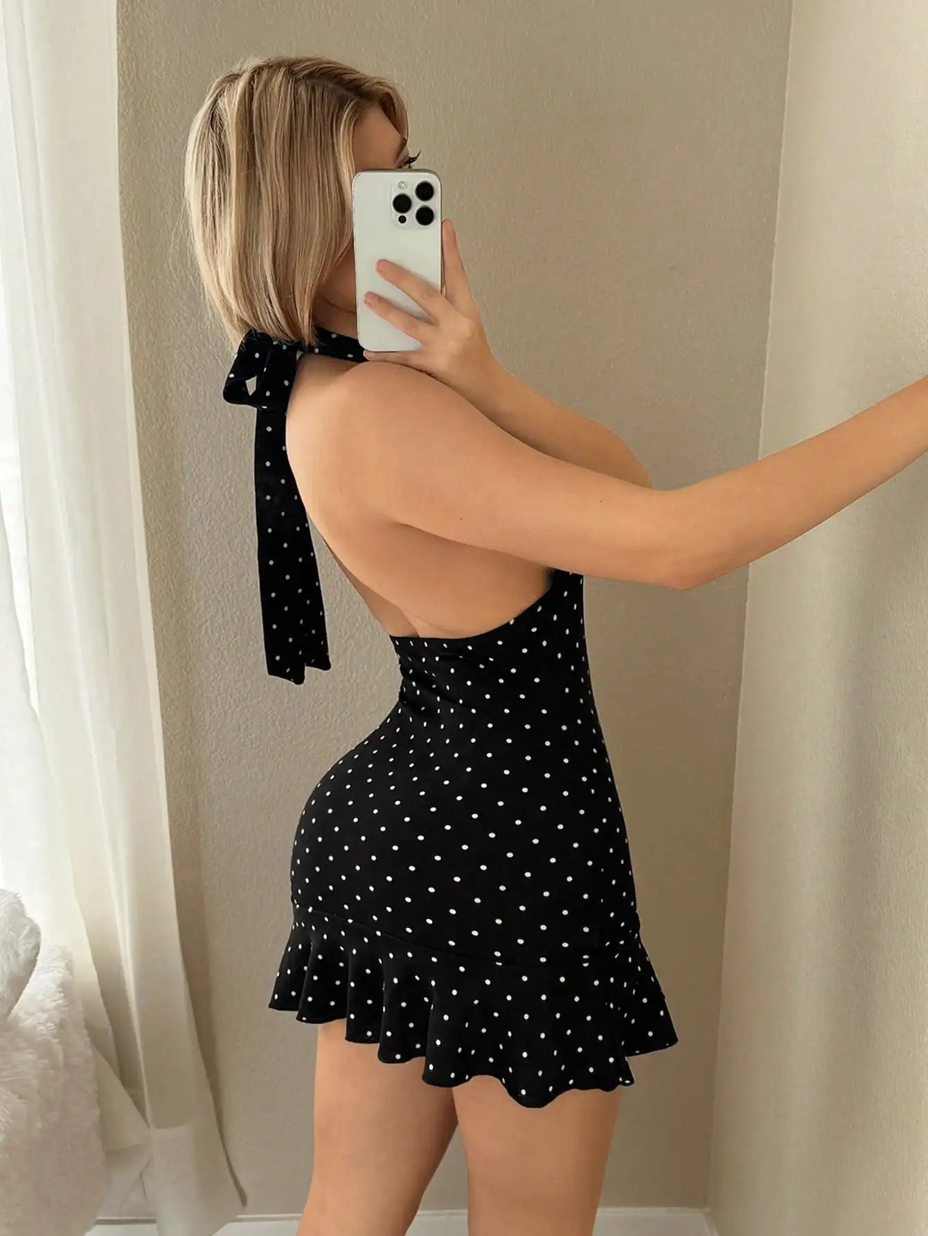Mini-robe sans manches noire à pois blancs, dos nu, col écharpe noué