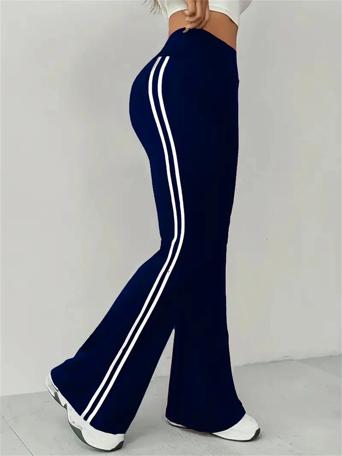 Pantalon évasé bleu foncé taille haute, bandes blanches sur la jambe.