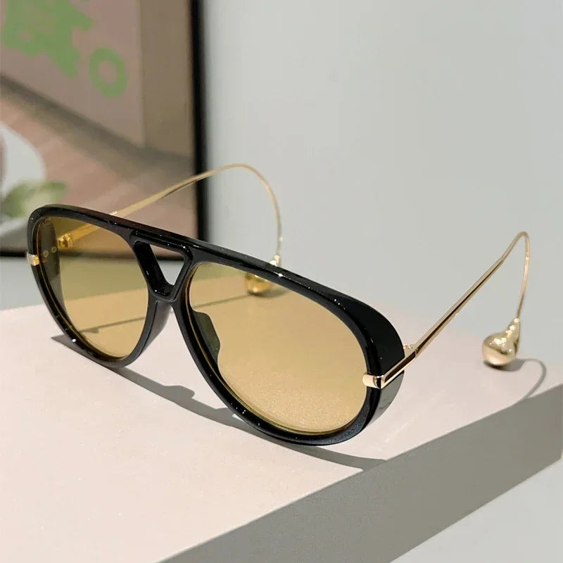 Lunettes de soleil pilote surdimensionnées à monture noire, verres ambrés.