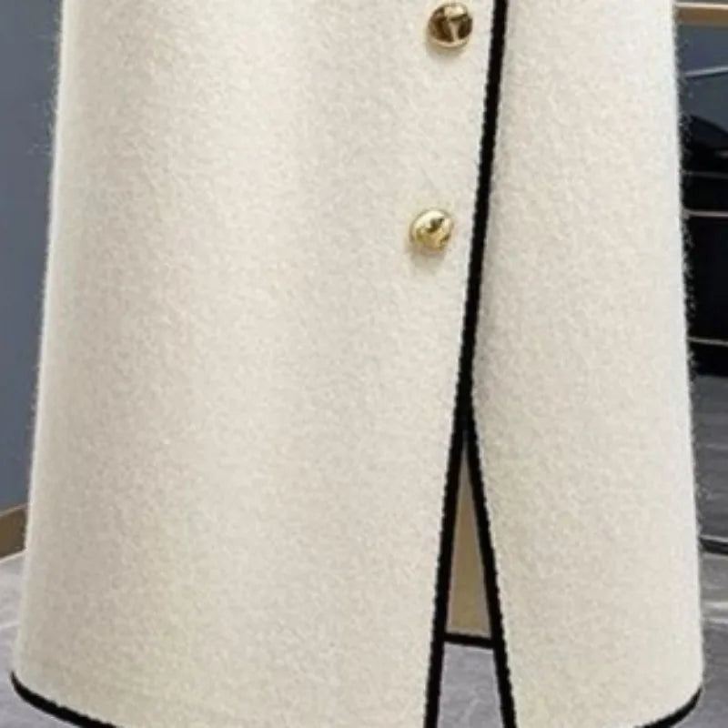 Jupe blanche avec passepoil noir, boutons dorés et fente avant partielle.