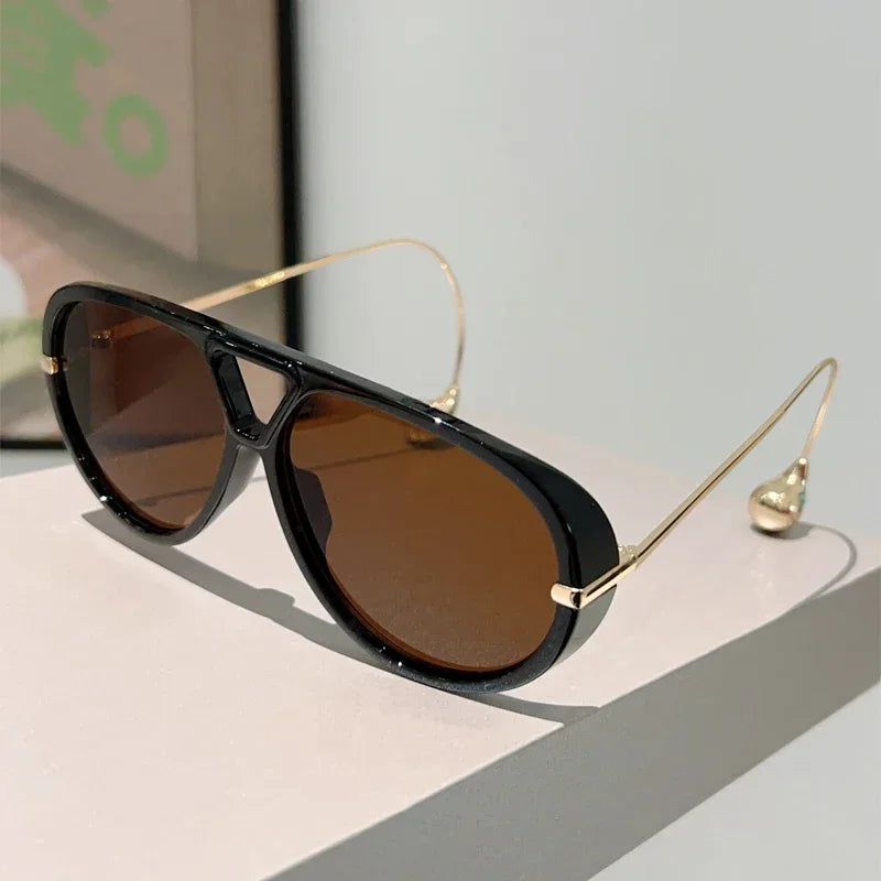 Lunettes de soleil pilote surdimensionnées à monture noire, verres marron teintés.