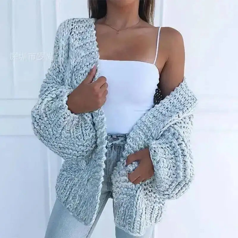 Cardigan en maille épaisse bleu ciel, manches chauve-souris et bordures côtelées.