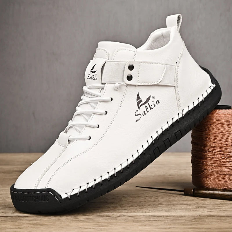 Chaussure décontractée en cuir blanc à lacets, semelle noire épaisse, piqûres décoratives.