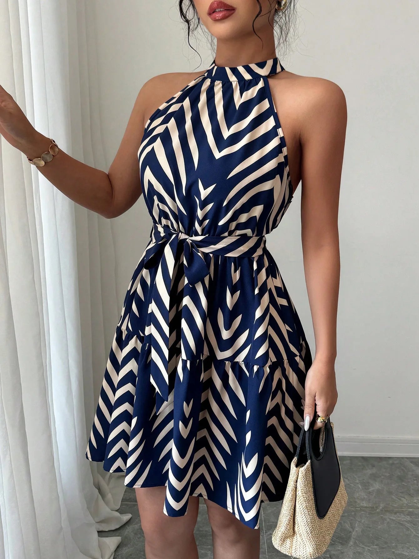 Robe midi bleu et blanc à col licou, sans manches, rayures ondulées, ceinture nouée