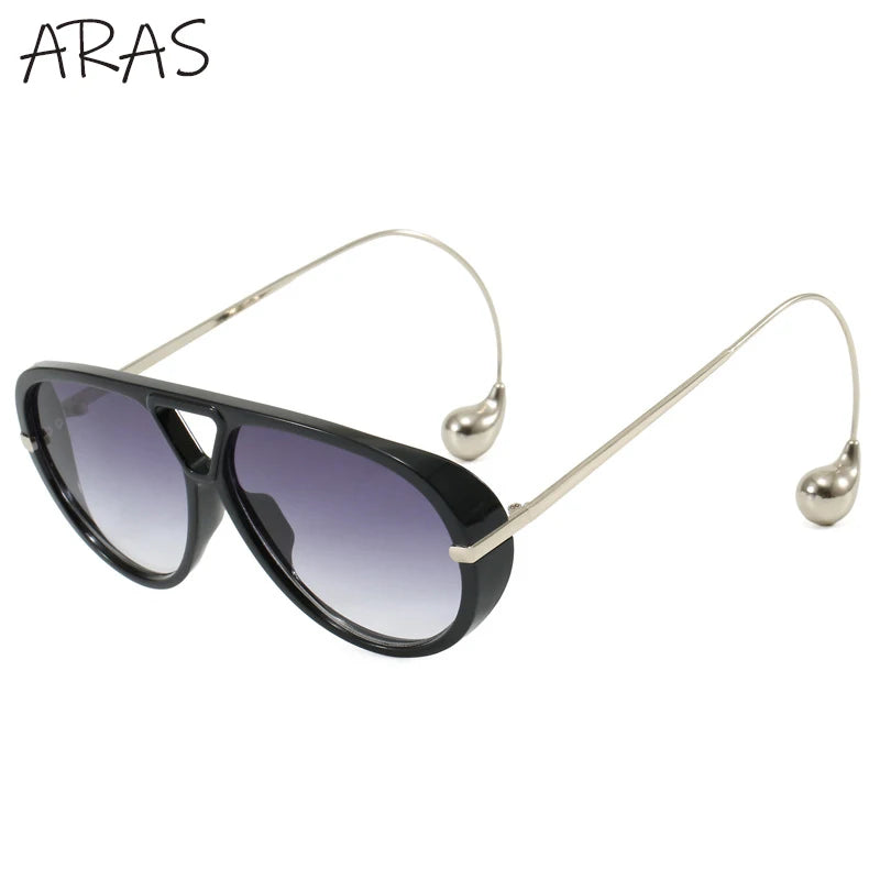 Lunettes de soleil ovales surdimensionnées vue de côté, monture noire et verres violets
