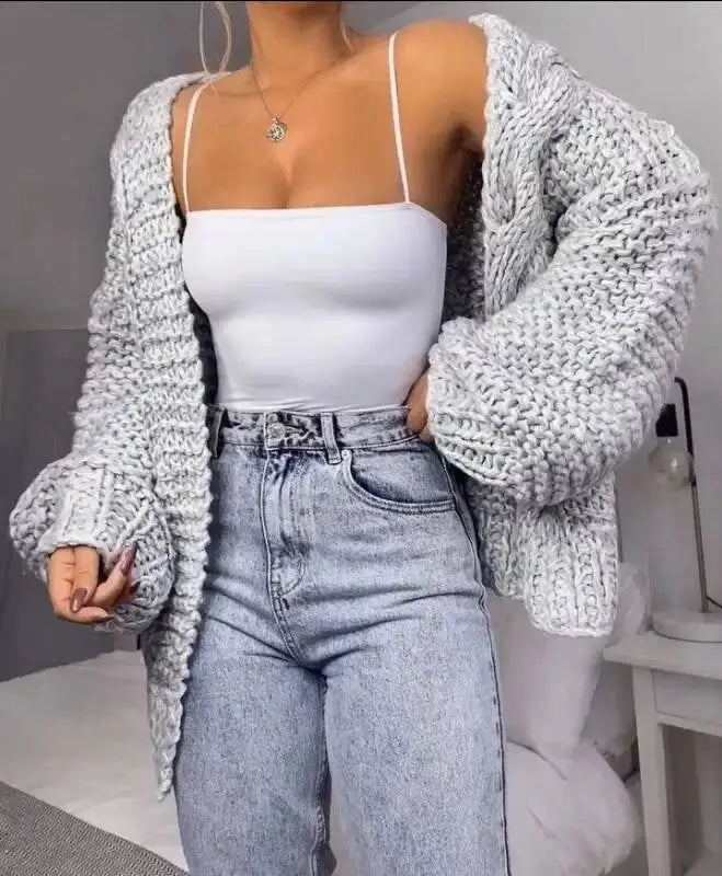 Cardigan en maille gris clair, manches chauve-souris volumineuses et ouverture devant.