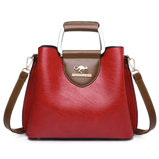 Sac fourre-tout rouge en cuir synthétique, poignée métal, logo central, bandoulières
