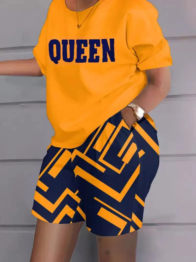 Ensemble t-shirt col rond orange avec logo QUEEN et short bleu à motifs, manches courtes.