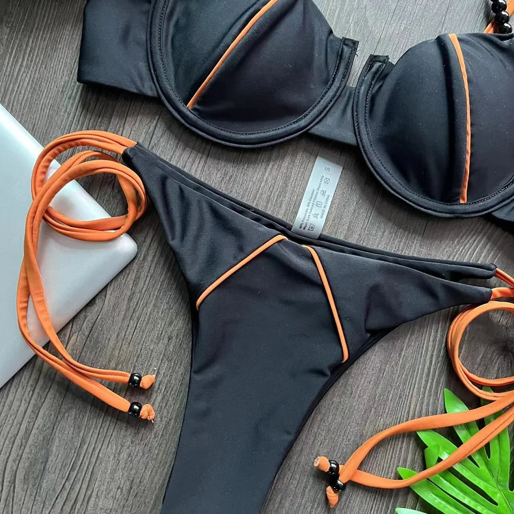 Haut de maillot balconnet et bas taille basse noirs, liseré orange, couture centrale