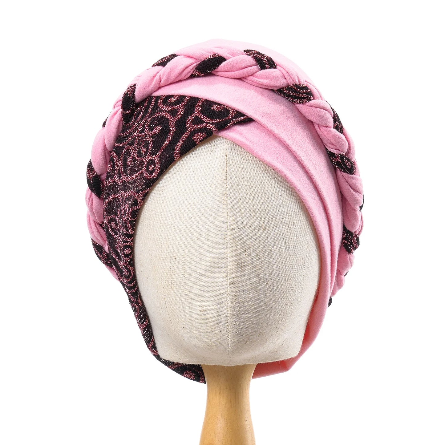 Bonnet turban tressé rose pâle avec motifs noirs sur le dessus.