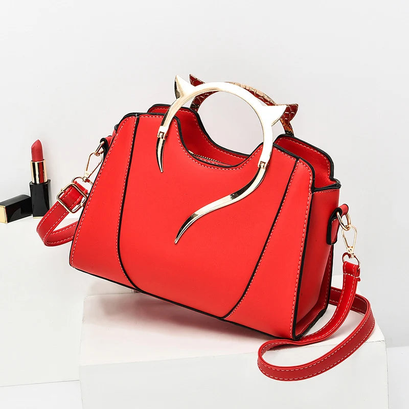 Mini sac à main rouge avec poignée chat dorée et bandoulière, détails métalliques dorés
