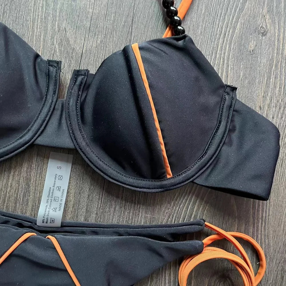 Haut de maillot balconnet noir à armatures, liseré orange et bretelles perles