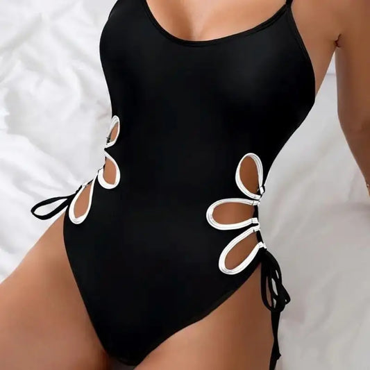 Maillot de bain une pièce noir à bretelles fines, découpes et nœuds latéraux.