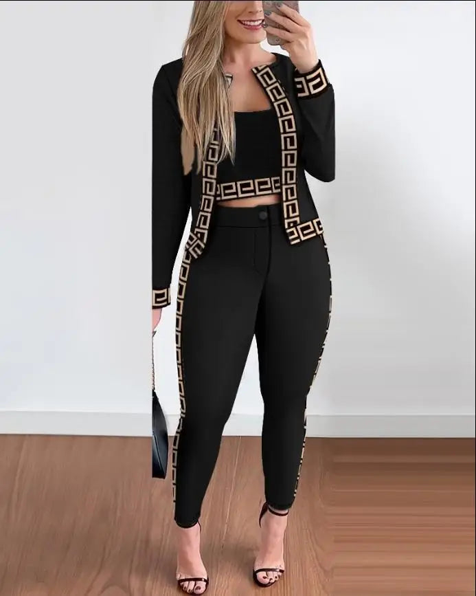 Ensemble 3 pièces noir : veste et pantalon slim noirs avec liserés dorés, top noir.