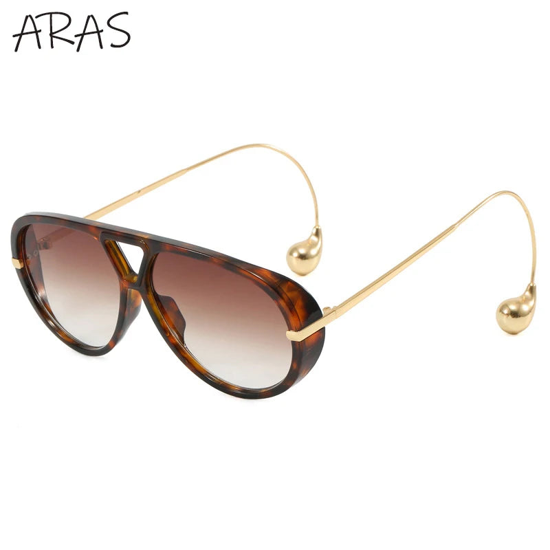 Lunettes de soleil ovales surdimensionnées vue de côté, monture noire et verres bruns