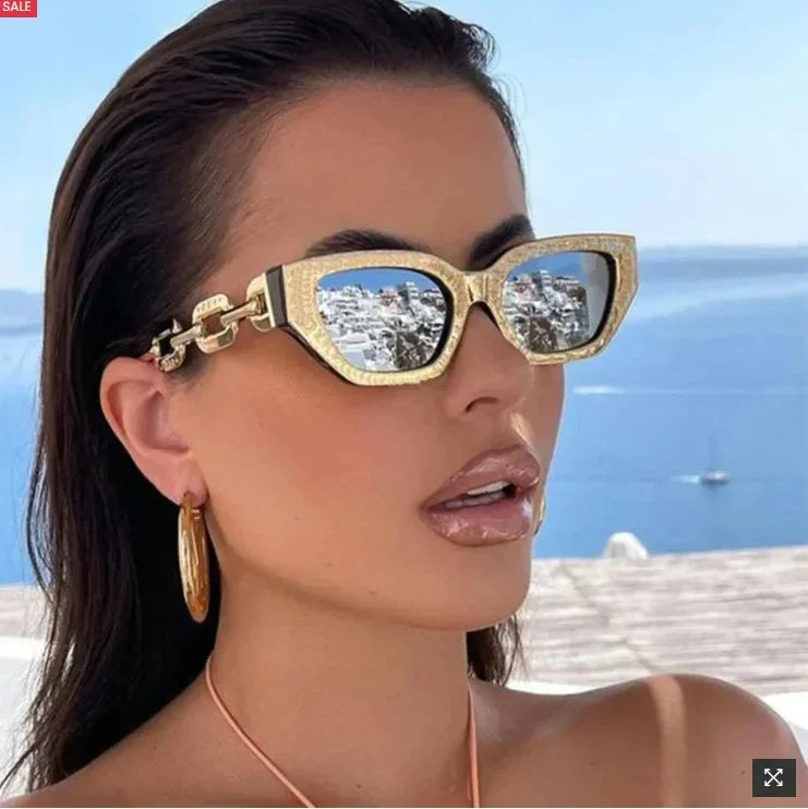 Lunettes de soleil œil de chat dorées, verres gris, portées de profil.