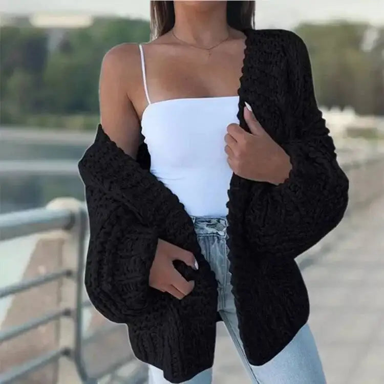 Cardigan en maille noire texturée, manches chauve-souris longues et coupe ample.
