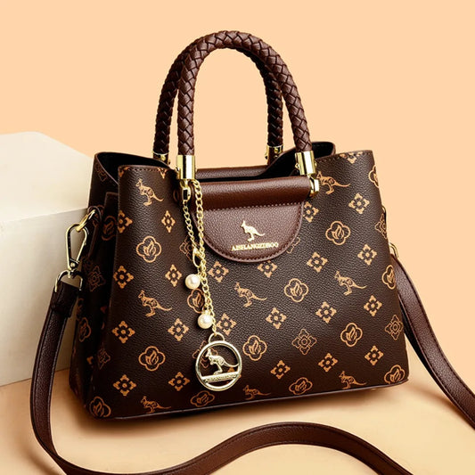 Sac à main en cuir noir avec poignées tressées, breloque perles et motif all-over.