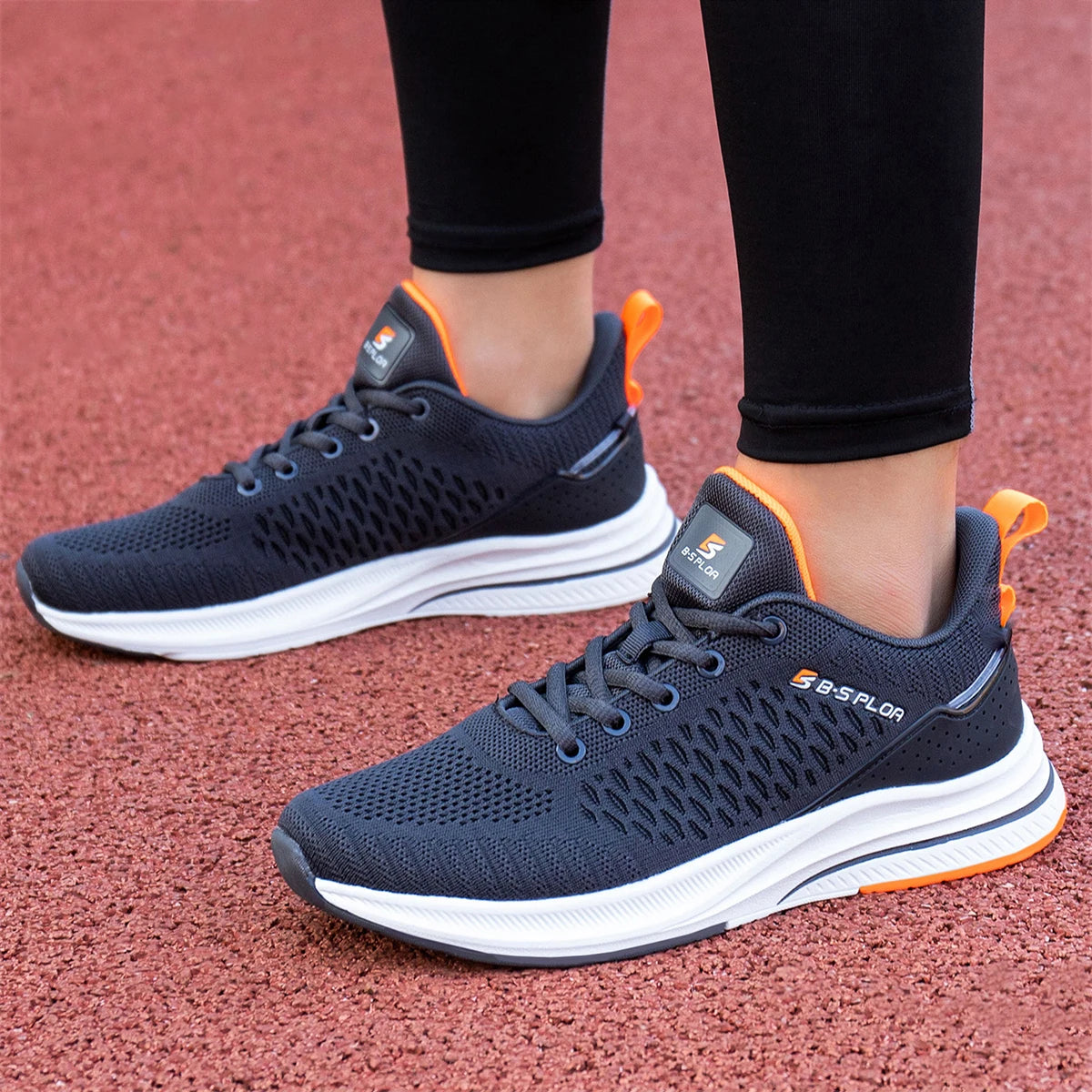 Chaussures de running homme bleu foncé, semelle blanche, touches orange.