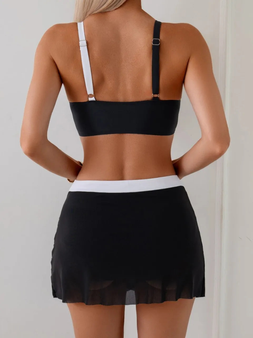 Maillot de bain deux pièces noir et blanc, vue arrière, bretelles réglables, jupe drapée