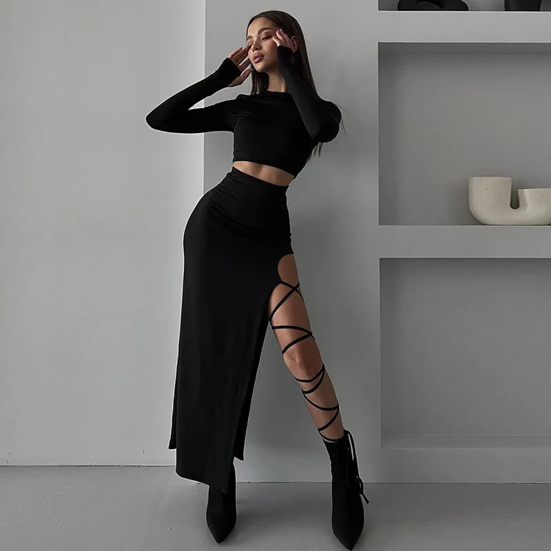 Ensemble noir : haut col rond manches longues et jupe longue fendue avec lanières sur la cuisse.