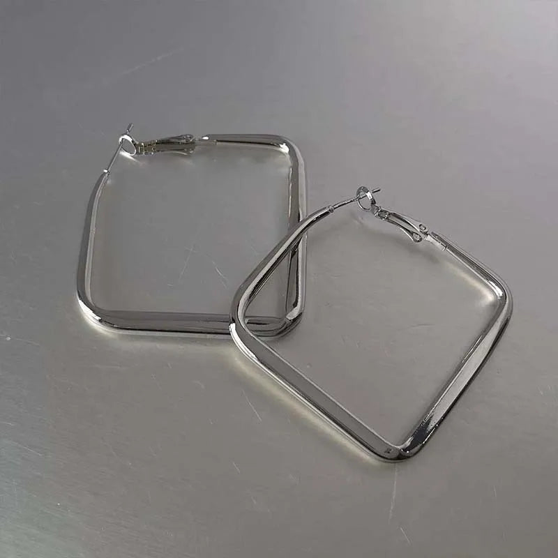 Boucles d’oreilles carrées en métal argenté, paire posée aux contours épais