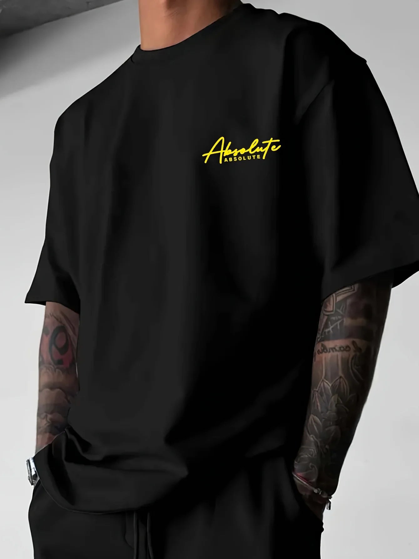 T-shirt noir col rond avec logo «Absolute» jaune sur la poitrine.