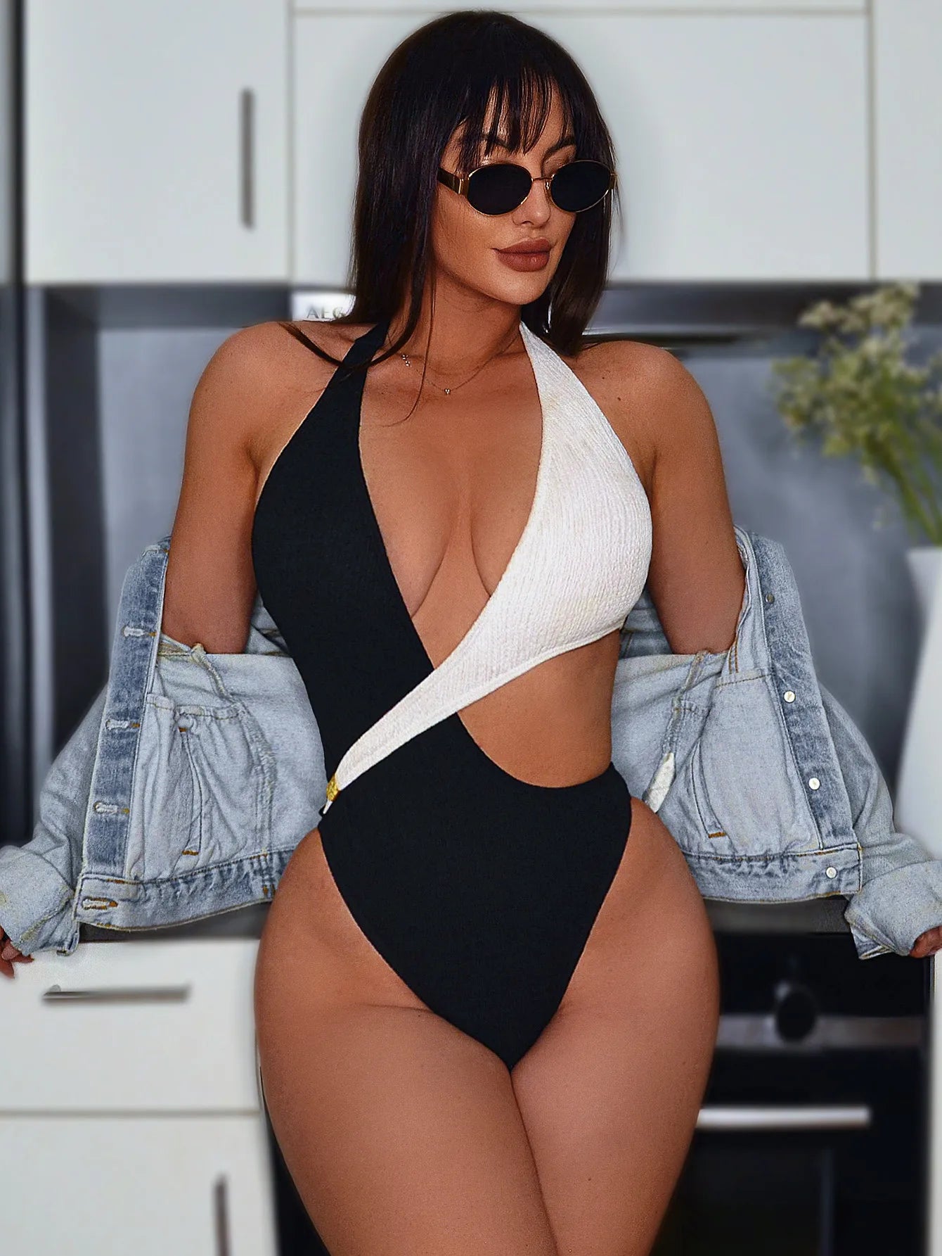 Maillot de bain une pièce noir et blanc à col plongeant, découpes sur le buste.