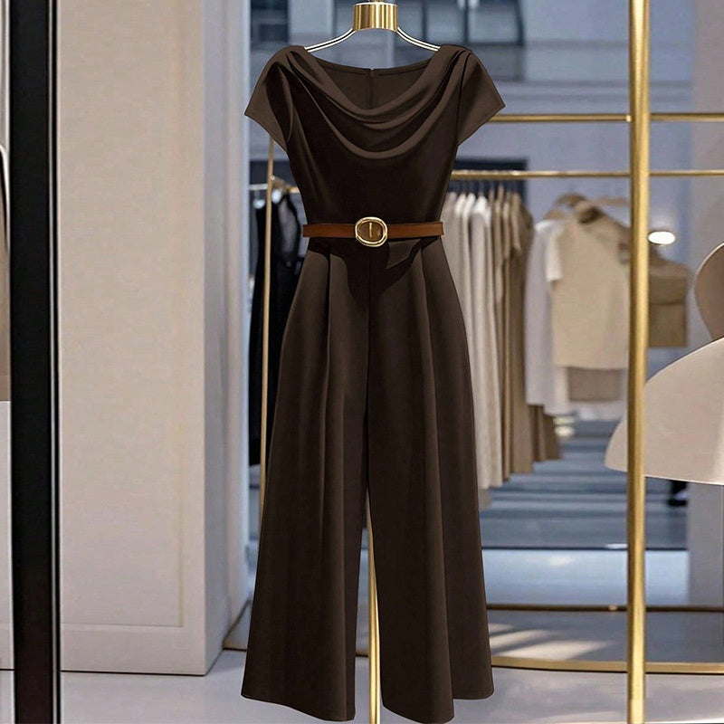 Combinaison satin noire, encolure drapée, ceinture fine avec boucle dorée, jambes évasées